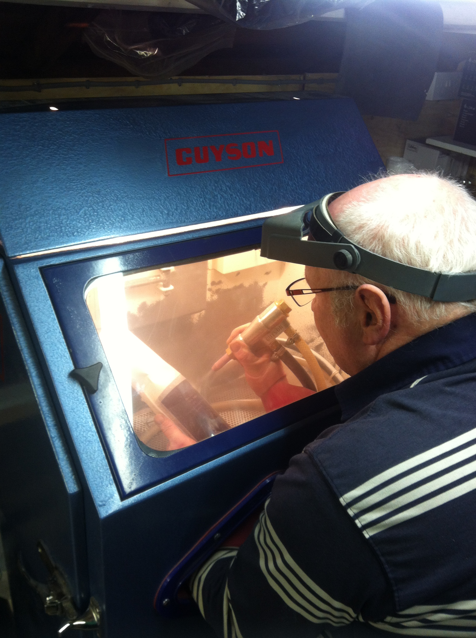 Sandblasting a glass which has had the mask adeered to the glass prior to blasting inside the cabinet made for the purpos