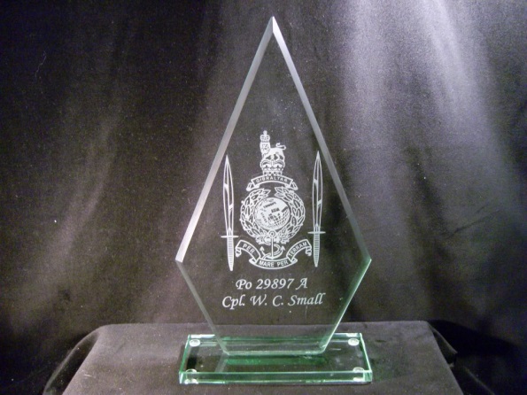 A Memory of My Service Career. This is a diamond shaped glass engraved with a Royal Marines Globe and Laurel Crest and two commando daggers at either side. It has my name at the bottom.