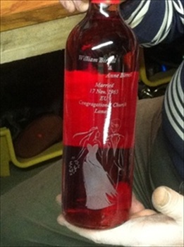 Glass Engraving can be a combination of sandblast engraving and hand engraving. This bottle was commissioned to commemorate a Wedding and the words were sandblast engraved, while the image of the bride & groom were hand engraved