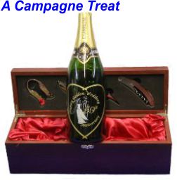 This photograph is of a champagne bottle with the front label removed and engraved in its place is a large heart inside of which is engraved a bride and groom suronded by the words Happy Golden Wedding Anniversary and the no 50. All of the engravings ar infilled with gold pain except the brides dress which is infilled with silver paint.