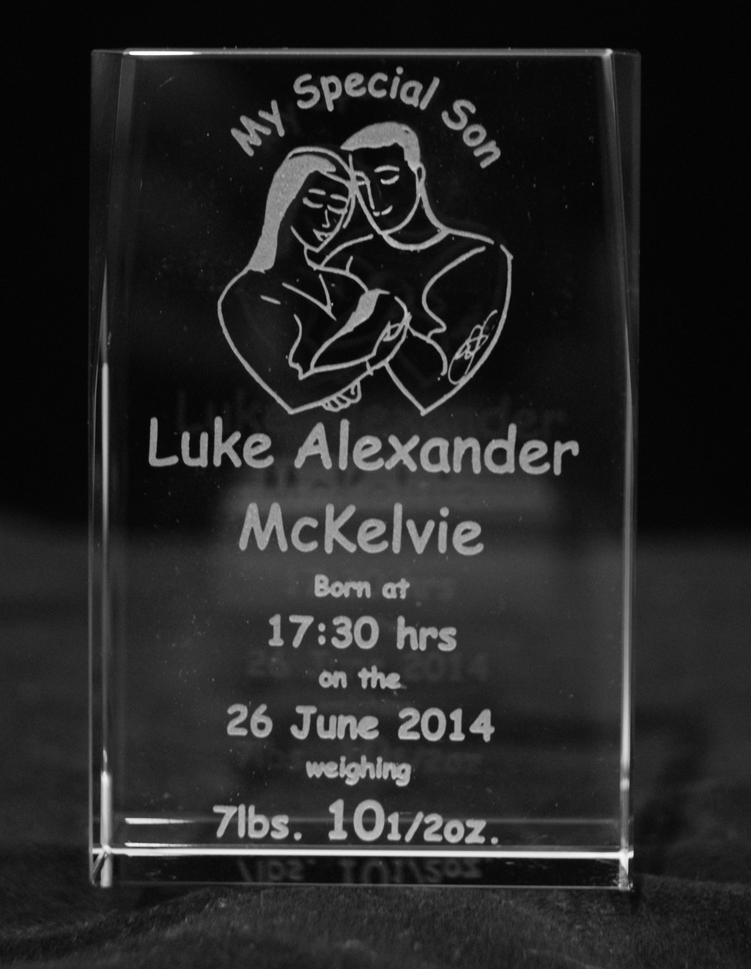 This is a glass block engraved with mother and father holding a new born baby. Above them and engraved in a curve is the words My Special Son. Below the parents is engraved the details of the birth, time, date and weight of the baby.