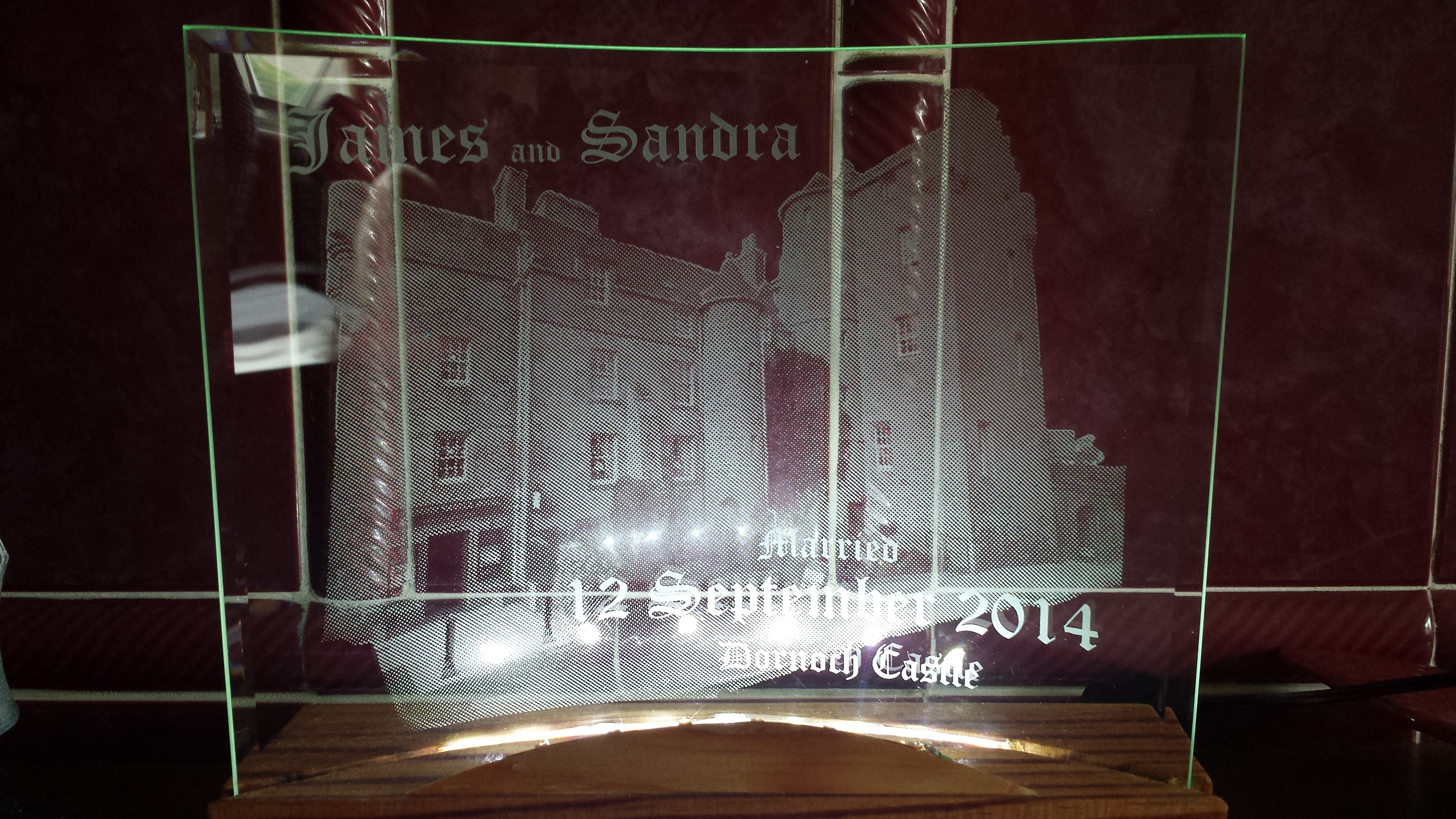 This is a picture engraving of the Dornoch Castle hotel directly onto the back of a piece of curved glass.On the front of the glass is engraved James and Sandra and the date and location of the marriage. Engraved in this manner creates depth of field and gives a 3D effect.