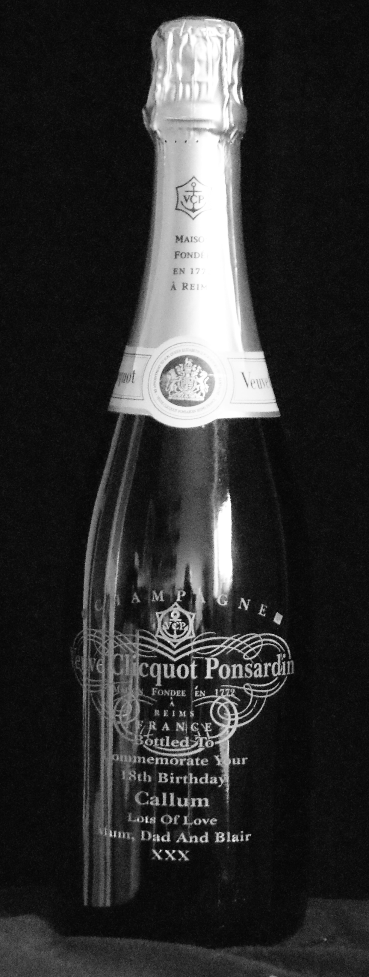 This is a photograph of a bottle of Champagne with the label removed and an image  of it engraved on to that position with a personal message also.